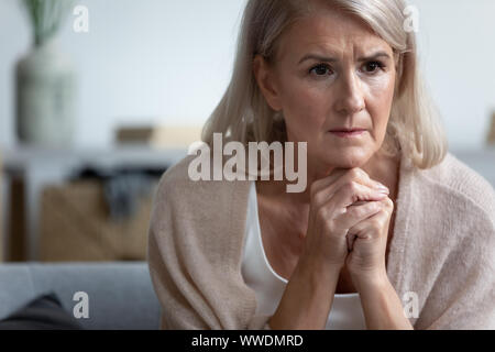 Reife Frau sitzen nur verärgert, Denken, Unwohlsein Stockfoto