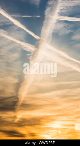 Vielen Kondensstreifen von Passagier Flugzeuge sind über den Abend Himmel über Zürich, Schweiz, während des Sonnenuntergangs. Stockfoto