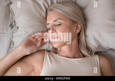 Ruhige schöne reife Frau schlafen im Bett ganz nah Stockfoto