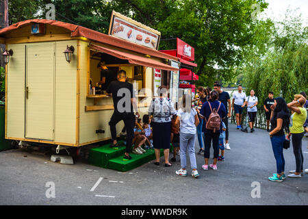 Die Menschen waren kaufen von einem Shop in König Mihai I Park (Herastrau Park) in Bukarest, Rumänien, 2019. Stockfoto