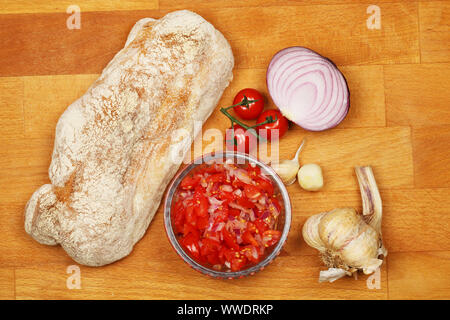 Zutaten für eine Tomate und Zwiebel rot Bruschetta auf einer hölzernen Schneidebrett Stockfoto