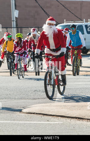Eine Gruppe von Menschen tragen Santa Claus Outfits überqueren die Straße auf dem Fahrrad, wie sie in der jährlichen Tour Delanta am 22. Dezember 2018 in Atlanta. Stockfoto