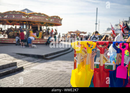 Kunststoff Spaten zum Verkauf in der Nähe von Merry go round am Meer Stockfoto