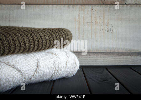 Nahaufnahme von zwei Gewirke aus natürlichen wolle Pullover, auf einem schwarzen Holztisch, selektiver Fokus Stockfoto