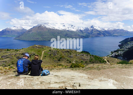 Paar genießt die Aussicht auf den Lake Wakatipu von Queenstown Hill. Queenstown, Otago, Neuseeland. Stockfoto