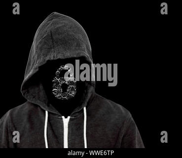 Hooded bedrohlichen Mann mit unsichtbaren Gesicht, der ein schwarzes Top mit einem Computer sperren, die von den Hackern kriminelle Arbeit gebrochen wurde. Stockfoto