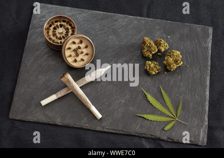 Marihuana Gelenke bereit zu rauchen, hohe Qualität cannabis Knospen, Schleifer und Marihuana Blatt in schwarzem Stein fach Gourmet Unkraut auf dunklem Hintergrund. Stockfoto