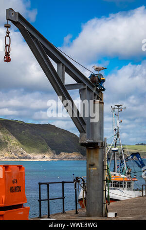 Kran und gestapelten Fisch Aufbewahrungsboxen in Gelb, Blau und Orange auf der Hafenmauer in Mevagissey Cornwall GROSSBRITANNIEN Stockfoto