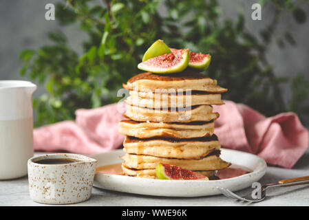 Pfannkuchen mit Sirup und Feigen an der Spitze. Leckeres Frühstück. Stapel von Flauschigen amerikanische Buttermilch Pfannkuchen Stockfoto