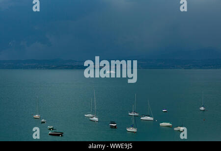 Gardasee, Italien - 13 August 2019. Der Blick von oben auf den Gardasee ist fabelhaft. Ein düsterer Himmel warten auf ein Gewitter. Schiff, Boot, Frische, Regen. Stockfoto