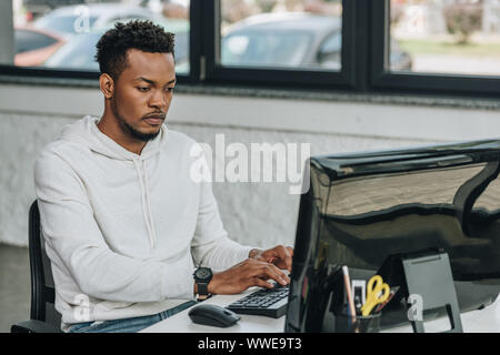 Schöne afrikanische amerikanische Programmierer arbeiten am Computer im Büro Stockfoto