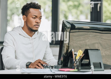 Junge afrikanische amerikanische Programmierer arbeiten am Computer im Büro Stockfoto