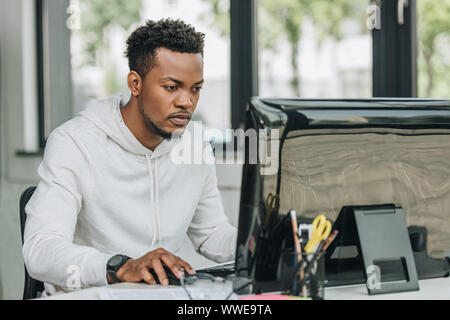 Aufmerksame afrikanische amerikanische Programmierer arbeiten am Computer im Büro Stockfoto