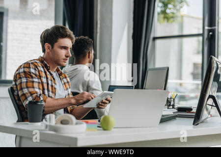 Selektiver Fokus der junge Programmierer im Büro in der Nähe der afrikanischen amerikanischen Kollegen arbeiten Stockfoto