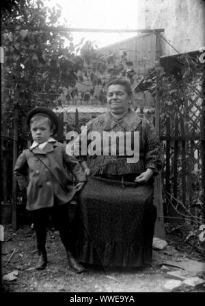 AJAXNETPHOTO. 1889-1900 (ca.). Frankreich (genaue Lage unbekannt.). - Familie SNAPSHOT-FRAU SITZT MIT JUNGEN im umzäunten Garten. Bild vom ursprünglichen GLASPLATTE NEGATIV; DATUM QUELLE VON GLASPLATTE BOX DECKEL. Fotograf: unbekannt © DIGITAL IMAGE COPYRIGHT AJAX VINTAGE BILDARCHIV QUELLE: AJAX VINTAGE BILDARCHIV SAMMLUNG REF: AVL PEO FRA 1889 110 Stockfoto