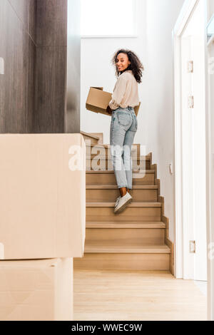 Volle Länge Blick auf schöne afrikanische amerikanische Frau zu Fuß oben halten, und auf der Suche an Kamera Stockfoto