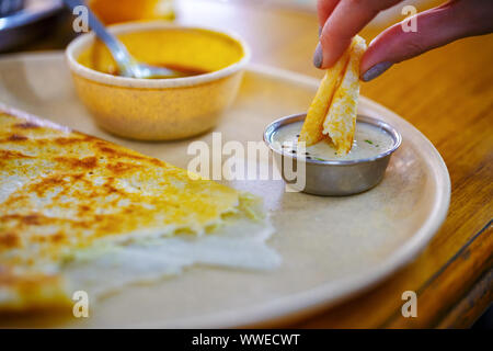 Dosa. Populäre Südindische Speisen. Mädchen isst Dosa, close-up Stockfoto