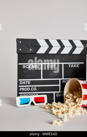 Lecker Popcorn mit Klappe und 3D-Brille isoliert auf Grau Stockfoto