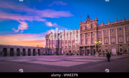 Sonnenuntergang mit dramatischen rosa Himmel und Wolken hinter die Fassade des Königspalastes von der Plaza de Armeria oder Waffenkammer Platz in Madrid, Spanien Stockfoto