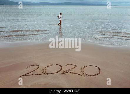 2020 im Sand mit einer Person im Hintergrund geschrieben. RF neues Jahr/Reisen/Urlaub-Konzept. San Blas, Nayarit, Mexiko. Stockfoto