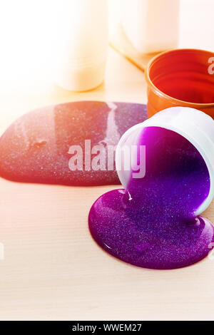 Der Schleim sich. Zutaten für die Helle glitzernde Schleim zu Hause. Violetter Schleim auf eine Tabelle aus Kunststoff Behälter. Stockfoto