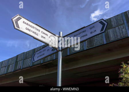 Leinpfad Richtung Wegweiser übersicht Wanderwege und Entfernungen an der Kreuzung des Flusses Wey und Basingstoke Canal in Weybridge, Surrey, Großbritannien Stockfoto