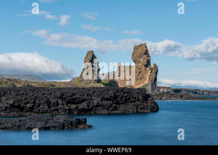 Lóndrangar beeindruckende Felsformation an der West Küste von Island an einem sonnigen Sommertag mit sanften Wellen des Ozeans Stockfoto