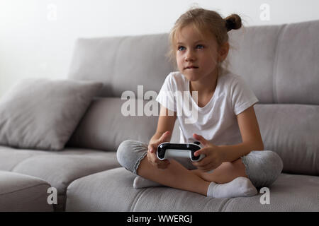 Schwere kleine Mädchen spielen Videospiele zu Hause Stockfoto