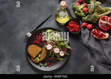 Brokkoli Schnitzel serviert mit Granatapfel Salat. Gesund Vegan essen. Fettarme Ernährung Stockfoto