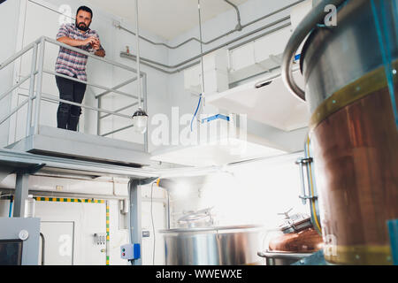 Oktoberfest. Verkostung frisch gebrautes Bier. Brewer hält Glas mit Handwerk Bier. Brauerei Konzept. Mann mit Bier in der Tasse. Alkohol. Männliche Brauer hält Stockfoto
