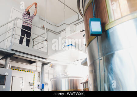 Oktoberfest. Verkostung frisch gebrautes Bier. Brewer hält Glas mit Handwerk Bier. Brauerei Konzept. Mann mit Bier in der Tasse. Alkohol. Männliche Brauer hält Stockfoto