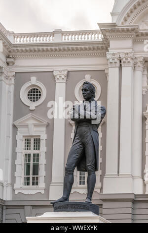 Singapur - März 20, 2019: Nahaufnahme von Schwarz Bronze Statue auf weißen Sockel von Stamford Raffles vor der weißen und grauen Fassade der Victoria Theatre Stockfoto