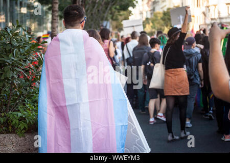 Mann, eingewickelt in eine transsexuelle Flagge von hinten während einer Gay Pride gesehen. Dieses Flag ist eines der Symbole der LGBTQ und Transgender und Gemeinschaft Stockfoto