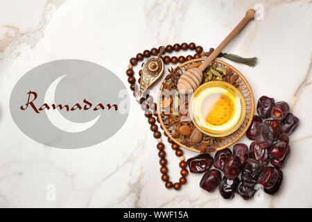 Muslimische Lampe, Termine, Honig, tasbih und Wort RAMADAN auf hellen Hintergrund Stockfoto