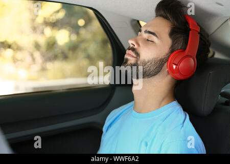 Junger Mann hören im Auto zu Hörbuch Stockfoto