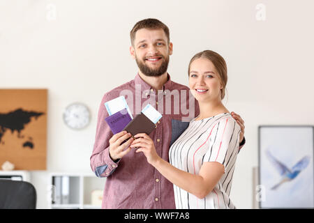 Glückliches Paar mit Pässe und Tickets im Reisebüro Stockfoto