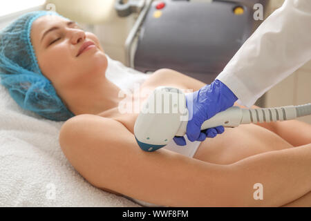 Schöne Frau, die sich Verfahren der Laser Haar Entfernung im Beauty Salon Stockfoto