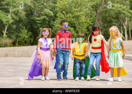 Süße kleine Kinder als Superhelden im Freien gekleidet Stockfoto