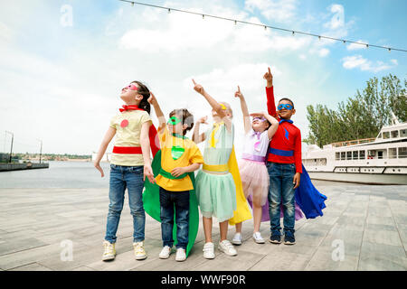 Süße kleine Kinder als Superhelden im Freien gekleidet Stockfoto