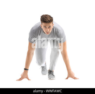 Sportlicher junger Mann in Crouch Startposition auf weißem Hintergrund Stockfoto