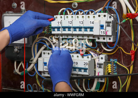 Elektriker Anschließen der Drähte im Schaltschrank Stockfoto