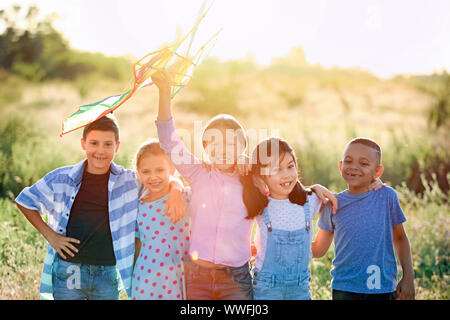 Kleine Kinder fliegen Drachen in Feld Stockfoto