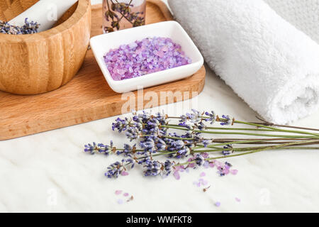 Lavendelblüten mit Meersalz und Handtuch auf Licht Tabelle Stockfoto