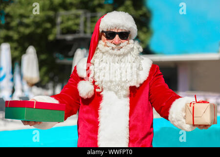 Cool Weihnachtsmann mit Geschenken an Resort Stockfoto