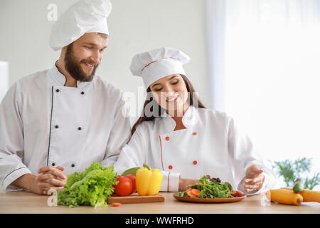Professionelle Köche Vorbereitung Gemüse Salat in der Küche Stockfoto