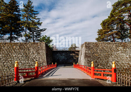 DEC 4, 2018 Aizu Wakamatsu, Japan - Aizu Wakamatsu Tsuruga Schloss Rokabashi rote Brücke und hohe Steinmauer. Fukushima Samurai Herr fortess in Edo peri Stockfoto