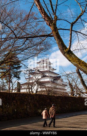 DEC 4, 2018 Aizu Wakamatsu, Japan - Aizu Wakamatsu Tsuruga Schloss und touristische Spaziergang entlang der Steinmauer unter großen Bäumen im Winter. Fukushima Samurai Herr Stockfoto