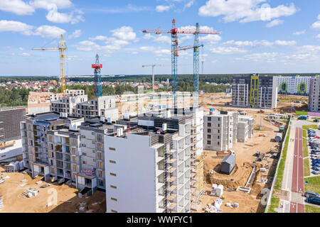 Luftbild des neu gebauten Wohnhäuser. Turmdrehkrane gegen den blauen Himmel Hintergrund Stockfoto