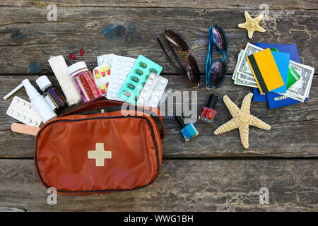 Sommer der Frauen Strand Zubehör für Ihr Meer Urlaub und Erste Hilfe Kit im alten Holz- Hintergrund. Konzept der Medikation in Reise erforderlich. Ansicht von oben. Stockfoto