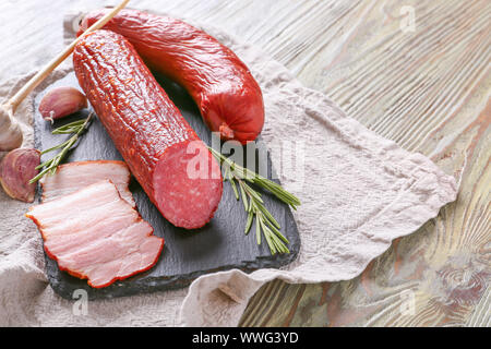 Schiefer Platte mit Auswahl an Würstchen auf hölzernen Tisch Stockfoto